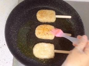 把饭团放入平底锅，再刷一层酱油。
