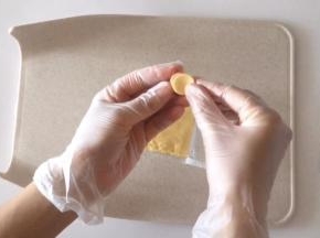 用裱花嘴圆形的一端在芝士片上压出小圆片，贴在火腿片上。