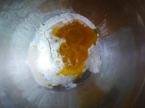 把南瓜泥、中筋面粉、糖、干酵母、玉米油放在盘子里，混合搅拌成棉絮状。