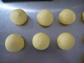 把面团平均分成8份，其中6份用来做小熊的头部，把面团滚圆。