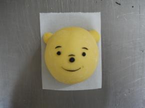 把做好的眉毛、眼睛、嘴巴和鼻子粘在小熊的脸上。可以用一点点水刷在小熊脸上来粘住这些小配件。