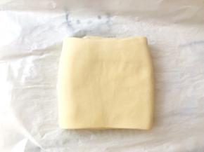 之后将面片折成3折，包裹上油纸放冰箱冷冻10分钟，让面片降温