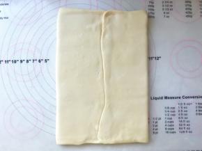 将两侧的面片向中间对折，接口处捏紧，将黄油包裹好，松弛1分钟