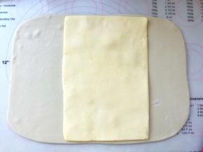 裁掉包裹黄油的保鲜袋，将黄油片摆放在面片中间