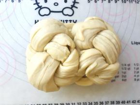 将编好的辫子翻个面，将两侧向中间对折，对折处捏在一起