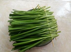 用开水烫过的竹签，把韭菜串在一起，这里穿4串出来
