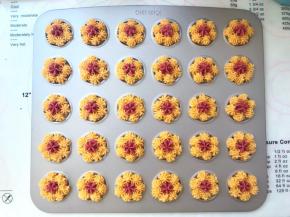 预热烤箱上火165度，下火160度，再将红色的面糊挤在花朵中间点缀