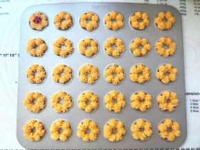 在学厨曲奇模具内挤上一圈黄色面糊，挤的时候注意要将每一小份花朵叠加在一起，这样烘烤后的曲奇花朵会粘在一起，形成一个大花朵