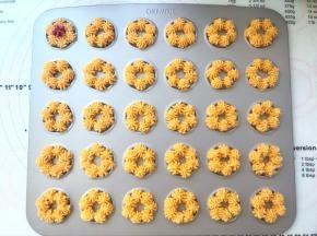 在学厨曲奇模具内挤上一圈黄色面糊，挤的时候注意要将每一小份花朵叠加在一起，这样烘烤后的曲奇花朵会粘在一起，形成一个大花朵