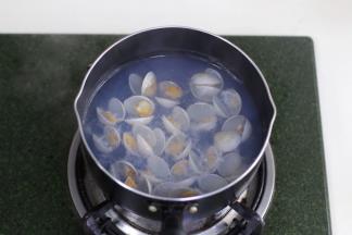 锅中倒入适量的清水煮沸，把冲洗净的蛤蜊放入锅中焯水至开壳。