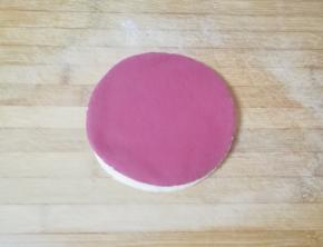 将擀好的两种颜色的面团摞起来，再次擀开。