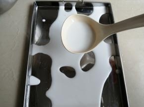 舀入一勺粉浆，粉浆量不宜太多，我这个是电饭锅配送的汤勺，就是一勺加小半勺吧，还要看你的肠粉盘大小而决定粉浆量。粉浆放置时间长了，会分层，所以每次舀粉浆，都要先搅拌几下，再舀