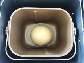 取下面包桶内的魔法刀，将面团揉均匀，放到面包桶内盖上盖上室温发酵至两倍大
