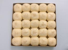 二发好的面团取出，表面喷上少许的水，撒上白芝麻