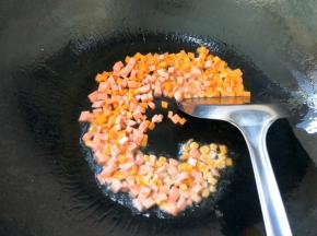 锅中倒入食用油，炒熟火腿肠和胡萝卜
