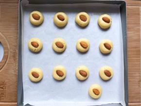 分成25克一个，戳圆，稍微压一下，放入一个杏仁在中间，轻轻向下压