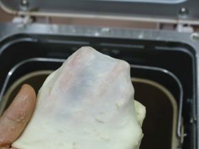 一个程序后加入软化好的黄油，继续和面到能拉出较薄的膜即可。