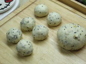 发酵好的面团按压排气，先分出6个35g的小面团，剩下的作为大面团，将它们都滚圆之后盖上保鲜膜松弛15分钟。