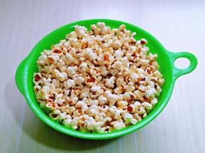 倒入漏篮中，再盖上盖子，用力摇一摇，这样可以把碎渣过滤掉，还有刚出锅的爆米花会黏连在一起，经过这样摇一摇，就粒粒分明啦！