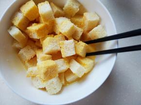 把切块的吐司放入鸡蛋液中，轻轻拌一下，把吐司丁都粘上蛋液