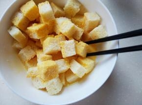 把切块的吐司放入鸡蛋液中，轻轻拌一下，把吐司丁都粘上蛋液