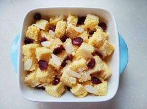 吐司放入碗中，撒上椰蓉，加入蔓越莓，加入杏仁片。