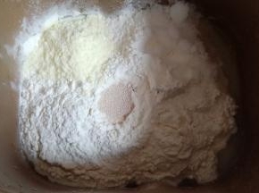 加入中筋面粉，奶粉和糖对角放，中间挖个洞放入酵母。