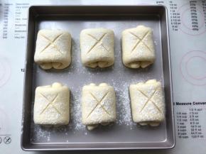 在面包表层过筛一层干粉，用锋利的刀片在表面划个叉