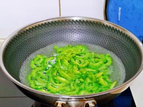 待锅中水烧开后，下入切好的苦瓜片。