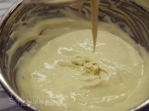 将牛奶倒入面糊中，用手动打蛋器快速翻拌均匀。