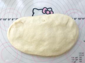 将面团倒在揉面垫上按压排气