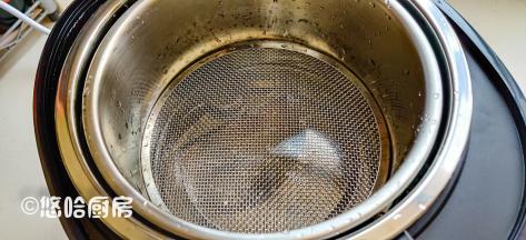 在饭煲中先放入甄子（甄子就是一个没有底的内胆），再放入蒸格，看得出蒸格和内胆有一定距离。蒸格网放置的时候要凸起的一面朝上放入。
