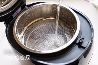 在瑧米脱糖饭煲内胆中，放入大蒸格，凸起的一面朝上。加入600毫升水。