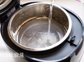 在瑧米脱糖饭煲内胆中，放入大蒸格，凸起的一面朝上。加入600毫升水。