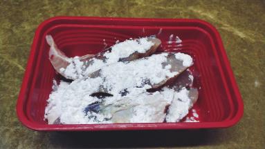 30分钟后倒掉腌出的汁水，用厨房纸吸干鱼块身上的水份，再放入生粉粘满鱼块上