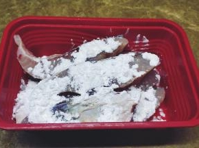 30分钟后倒掉腌出的汁水，用厨房纸吸干鱼块身上的水份，再放入生粉粘满鱼块上