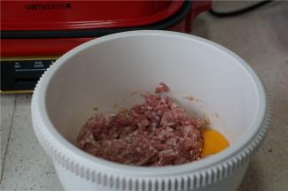 肉末入容器（要高一点，等一下方便搅拌），打个鸡蛋，加入料酒 ，生抽，胡椒粉，细盐。