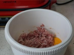 肉末入容器（要高一点，等一下方便搅拌），打个鸡蛋，加入料酒 ，生抽，胡椒粉，细盐。