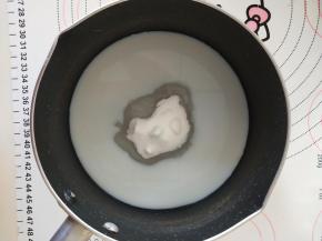 2、牛奶和细砂糖放入奶锅中加热。