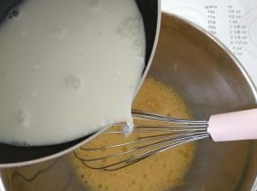 4、将椰浆牛奶冲到全蛋液中，边倒边搅拌。