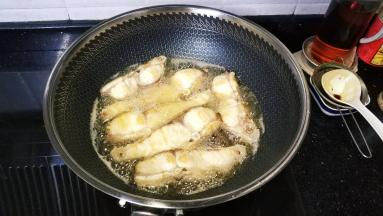锅里热油至七成热把鱼块倒入中火炸熟