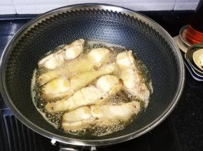 锅里热油至七成热把鱼块倒入中火炸熟