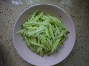 首先将黄瓜洗净，改刀后切成丝，加入盐、糖后拌匀，放入冰箱腌制15分钟。