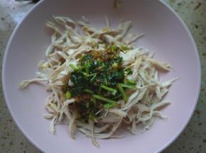 组合凉拌鸡丝，先把黄瓜丝垫底，然后放上鸡肉，最后把调料倒在上面。