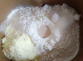 放入500克中筋面粉，对角放奶粉和糖，中间挖个洞放入酵母。