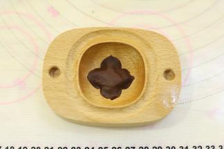 准备一个柿子木模具，洗净晾干后可以先均匀的抹上色拉油，2克巧克力桃山皮压好柿子的叶子部分。