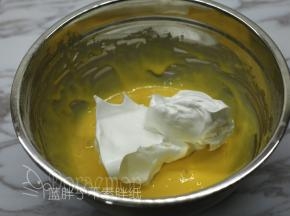 取1/3的蛋白霜加入到蛋黄糊中，用橡皮刮刀翻拌均匀。