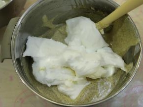 取三分之一的蛋清加入到蛋黄糊内，蛋抽画半圈的方式将蛋清和蛋黄糊混合均匀。