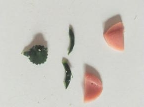黄瓜皮剪出小动物的眼睛、鼻子。火腿片切成两只耳朵。
