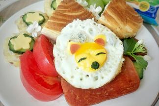 切出的芝士片等摆在蛋黄上做出小狐狸的样子。